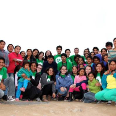 Peru B participants pose with children and parents from Hijos de 28 de julio